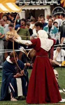 * A Norman lady in Red dress and white wimple shooting in front of a crowd